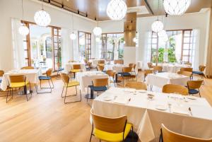 奇克拉纳－德拉弗龙特拉Iberostar Selection Andalucia Playa的餐厅设有白色的桌椅和窗户。