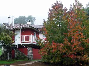 利亚内斯巴别酒店的红色的房子,有白色的门廊和一棵树