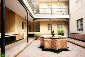 塞维利亚HSH Suites Corrala Triana的一座建筑中间带喷泉的庭院