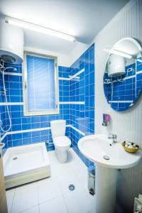 斯库台Luani A Hotel的蓝色瓷砖浴室设有水槽和卫生间