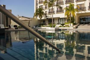 莱昂莱昂霍特桑HS酒店的一座棕榈树游泳池和一座建筑