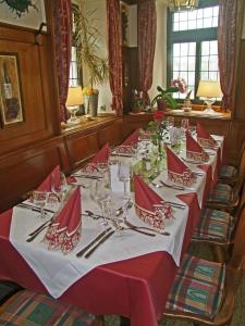 肯钦根贝勒酒店的一张长桌,上面有红色的餐巾和银器