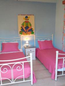 拉卡Cornelia的配有粉红色床单的客房内的两张床
