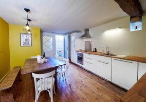 坎佩尔Chez Nolwenn的厨房配有木桌和白色橱柜。
