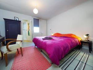 坎佩尔Chez Nolwenn的一间卧室配有一张大床和紫色毯子