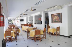 特尔马斯德里奥翁多Hotel De Las Artes的餐厅内带桌椅的用餐室