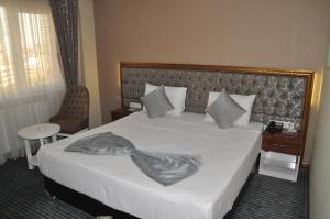 安卡拉赛拉大酒店的一间卧室配有一张带白色大床罩的床