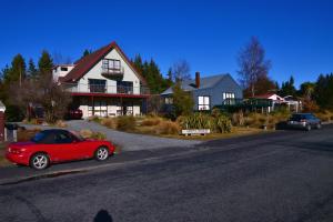 特卡波湖鱼篓屋住宿加早餐旅馆的停在房子前面的红色汽车