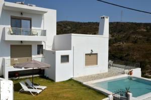 PsinthosBianca Suite & Home的一座白色的房子,在庭院里设有一个游泳池
