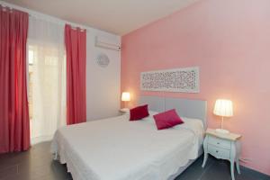 佛罗伦萨坎托戴米勒旅馆的卧室拥有粉红色的墙壁,配有红色窗帘