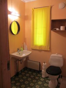 AustertanaVARANGER KITE CAMP的浴室配有水槽、卫生间和黄色窗帘