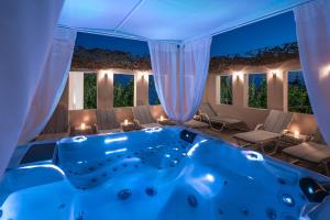 罗希姆诺Omiros Boutique Hotel (Adults Only)的窗户客房内的大蓝色浴缸