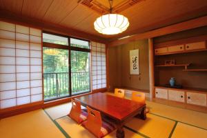 忍野村叶娜旅馆的配有木桌和橙色椅子的用餐室
