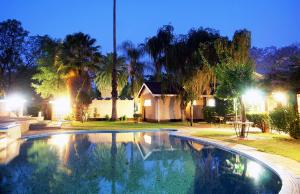 KadomaKadoma Hotel & Conference Centre的夜间在房子前面的游泳池