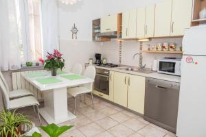 希贝尼克植物园度假屋的厨房配有白色橱柜和鲜花桌