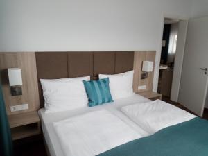 沃尔姆斯阿尔特斯·鲁德豪斯旅馆的一张带两个蓝色枕头的大白色床