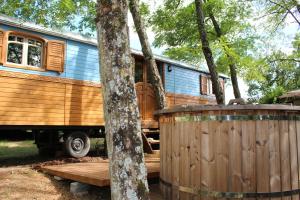 Cadalen卢罗特兹乐纳哈拉酒店的一辆停在树林中的蓝色木制大篷车