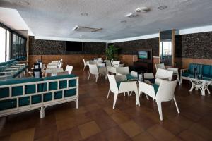 美洲海滩加泰罗尼亚黑金酒店的一间设有白色椅子和桌子的用餐室