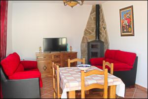 科尼尔-德拉弗龙特拉Chalet Vigía 114的客厅配有桌子和2把红色椅子