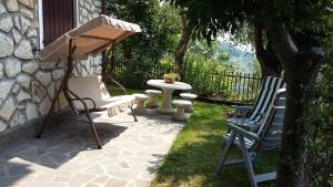 马罗内Il pozzo的庭院设有两把草坪椅和一张桌子