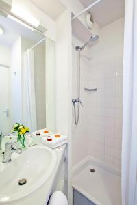 塞纳河畔伊夫里塞祖尔阿菲尔巴黎伊芙利酒店的白色的浴室设有水槽和淋浴。