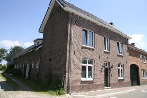 SchimmertDe Oude Koeienstal的街上有红砖建筑,有白色窗户