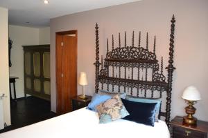 费尔盖拉什金塔莫斯泰罗酒店的一间卧室配有一张带大型木制床头板的床