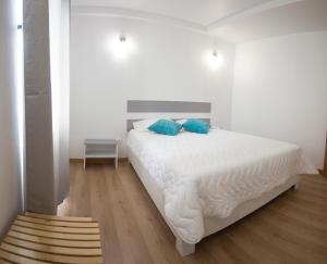 马达莱纳PIX Apartments的一间卧室配有白色床和蓝色枕头