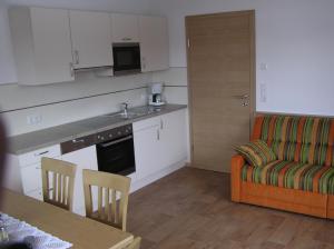 平茨高谷地霍勒尔斯巴赫Appartements Luegeck的厨房以及带沙发和桌子的客厅。