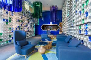 马德里奥斯卡媒介酒店的一间设有蓝色椅子和花瓶墙的房间