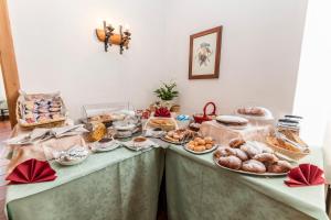 米苏丽娜苏拉帕斯酒店的两张桌子,上面摆放着不同类型的面包和糕点