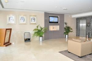 阿布扎比凤凰广场公寓酒店的大堂配有电视,室内种植植物