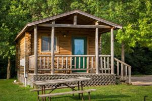 弗里蒙特Fremont RV Campground Cottage 21的木屋,在草地上设有长凳