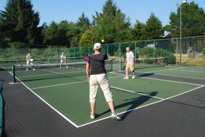 西塞德Seaside Camping Resort Studio Cabin 3的一群人在网球场打网球