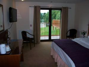 阿博因湖上小屋酒店的酒店客房设有一张床和一个阳台。