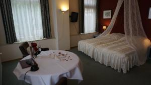 厄伊特赫伊曾厄伊特赫伊曾市镇大厅酒店的酒店客房设有一张床和一张白色的桌子。