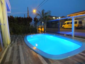 弗洛里亚诺波利斯Residencial Praia Mar的夜晚在院子里的一个蓝色游泳池