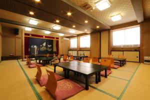 水上町仁田屋日式旅馆的一间会议室,配有桌椅和屏幕
