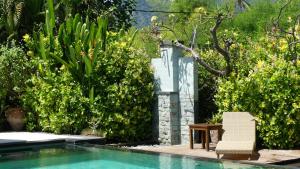 佩母德兰苏尼亚洛卡洋房和潜水中心酒店的靠近灌木丛的带椅子的游泳池