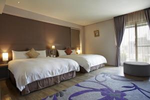 台中市米卡沙旅店的酒店客房设有两张床和大窗户。