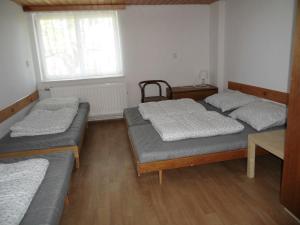 霍捷索瓦斯特拉Turistická ubytovna Zámeček的带三张床和窗户的客房