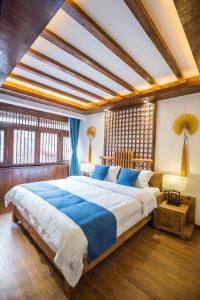丽江丽江悦途精品度假酒店的一间卧室配有一张带蓝白色床单的大床