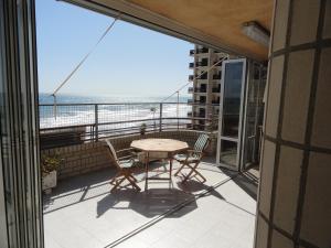 奥罗佩萨德尔马Apartamentos Raymar的阳台配有桌椅,享有海景。