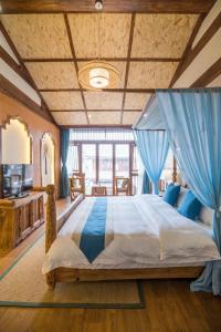 丽江丽江悦途精品度假酒店的大卧室设有一张蓝色窗帘的大床