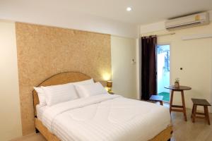 曼谷69区（廊曼机场）公寓式酒店的卧室配有一张白色的大床和一张桌子