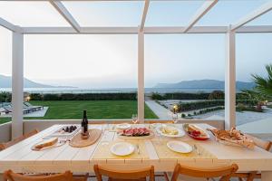 基萨莫斯Akti Villa的庭院里配有带食物和葡萄酒的白色桌子