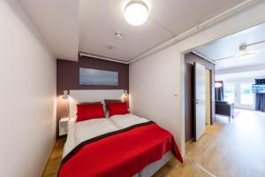 MelandsjøenDolmsundet Hotell Hitra的一间在房间内配有红色和白色床的卧室