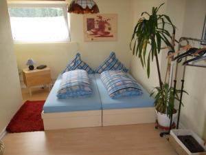 ReyersvillerFewo Reyersviller的一间卧室配有蓝色的床、枕头和植物
