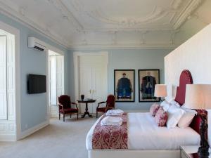 里斯本亲爱的里斯本希亚多宫套房旅馆的卧室配有一张床和一张桌子及椅子