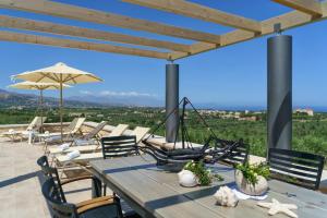 阿斯特里昂Luxury Villa Aria with Pool & Children's Area, 5km to Beach!的庭院里配有桌椅和遮阳伞